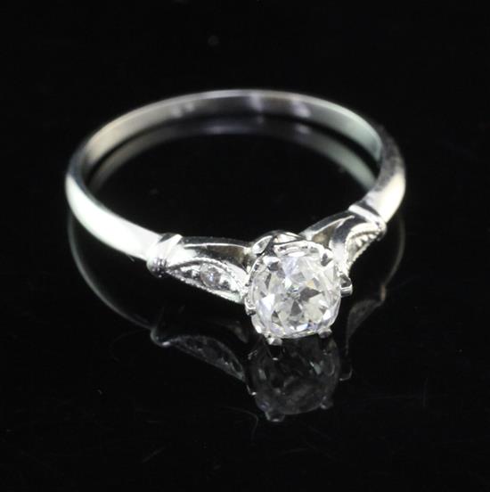 A platinum and single stone cushion cut diamond ring with diamond set shoulders, size K.